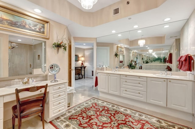 bathroom with a shower with door, vanity, and an inviting chandelier