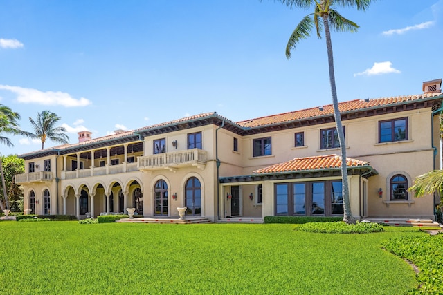 back of property featuring a yard and a balcony