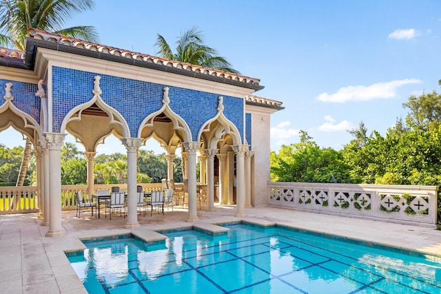 view of pool featuring an outbuilding and a patio area