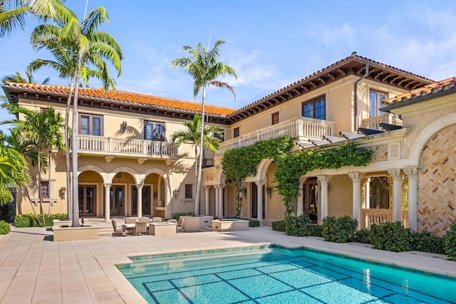 back of property with a balcony and a patio