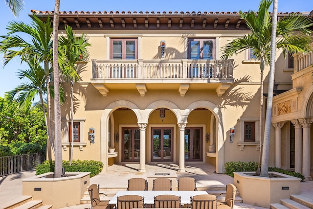 back of house with french doors, a balcony, and a patio area