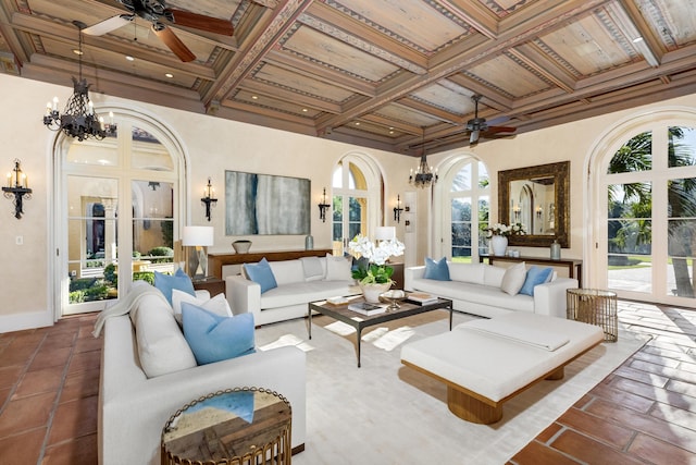 living room featuring ceiling fan with notable chandelier, beamed ceiling, and coffered ceiling