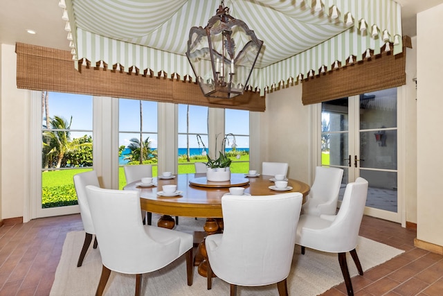 dining area featuring a wealth of natural light, french doors, and a notable chandelier