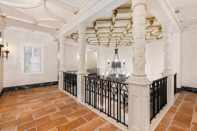 corridor with ornamental molding and a notable chandelier