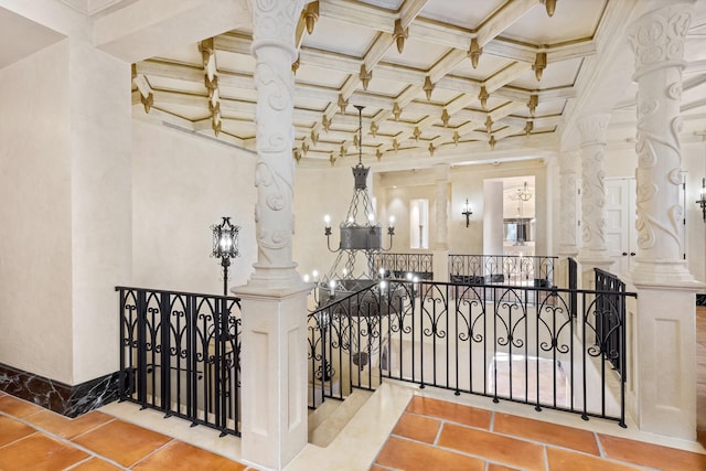 stairway featuring decorative columns, coffered ceiling, crown molding, beam ceiling, and a chandelier