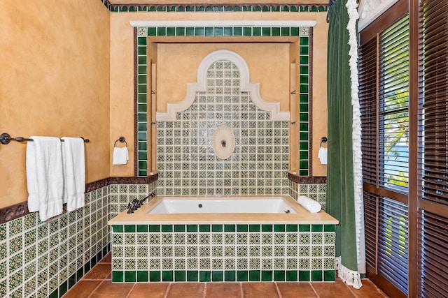 bathroom featuring tile patterned floors, a relaxing tiled tub, and tile walls