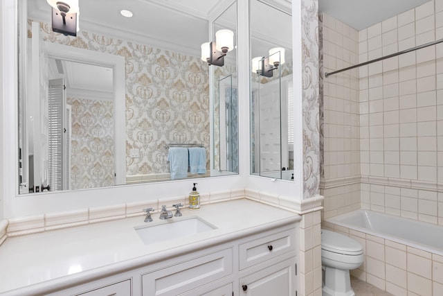 full bathroom with vanity, tiled shower / bath combo, toilet, and crown molding