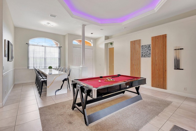 game room with pool table, a tray ceiling, decorative columns, light tile patterned floors, and crown molding