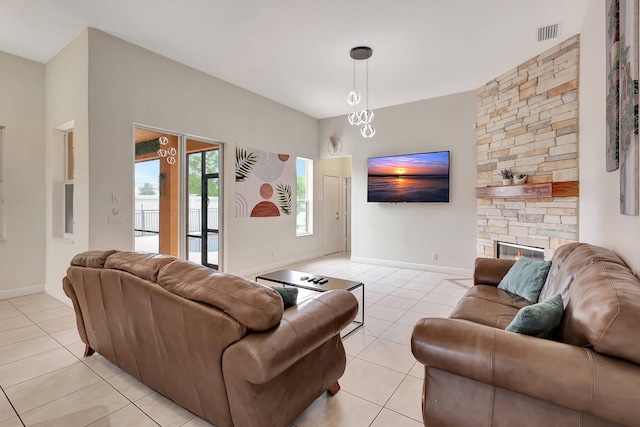 living room featuring light tile patterned floors and a stone fireplace