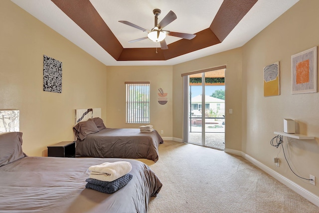 bedroom with ceiling fan, light colored carpet, a raised ceiling, and access to exterior