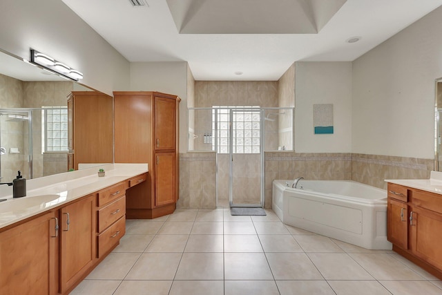 bathroom featuring tile walls, shower with separate bathtub, tile patterned floors, and vanity