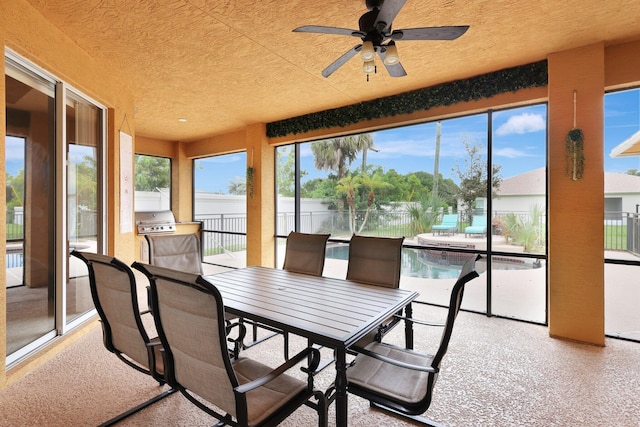 sunroom / solarium featuring ceiling fan