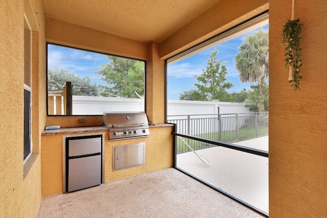 view of patio featuring an outdoor kitchen and a grill