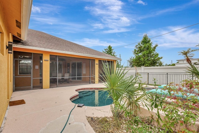 view of swimming pool with a sunroom and a patio