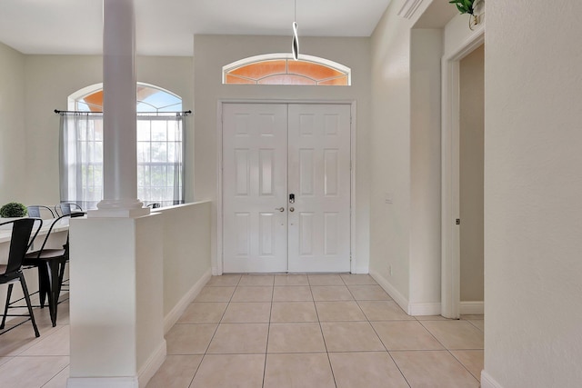 entrance foyer featuring light tile patterned floors and decorative columns