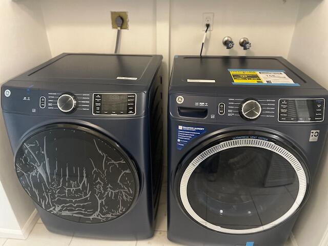 laundry room with independent washer and dryer and tile patterned floors