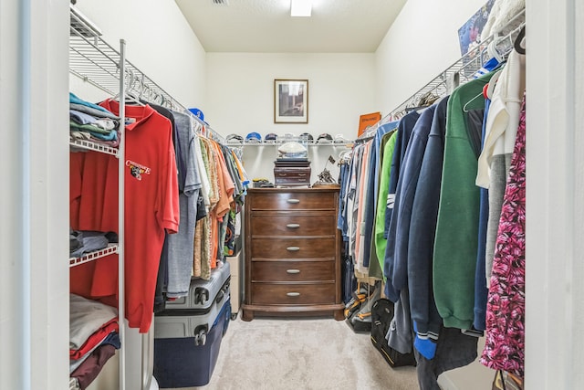 spacious closet featuring light colored carpet