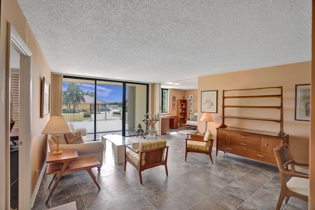 sitting room with baseboards, a wall of windows, and a textured ceiling