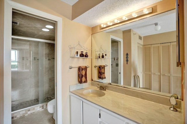 full bathroom featuring a stall shower, vanity, toilet, and tile patterned floors