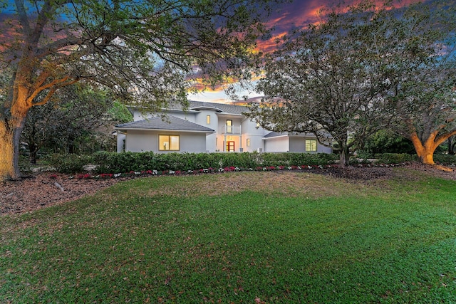 view of front of house with a front yard and stucco siding