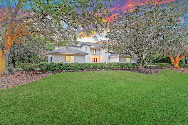 view of front of property featuring a lawn and stucco siding