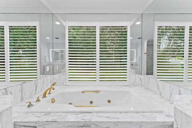 bathroom featuring a relaxing tiled tub, a healthy amount of sunlight, and ornamental molding