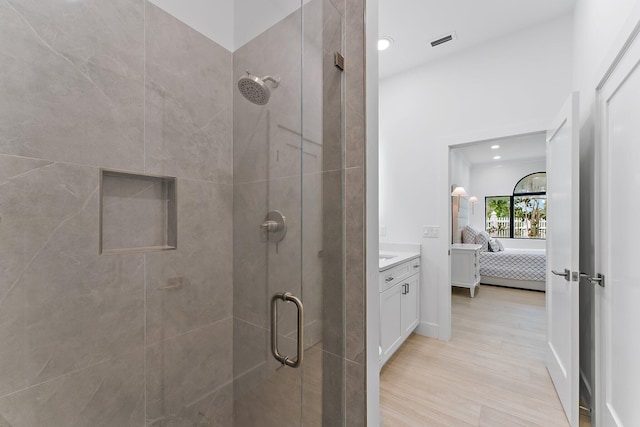 bathroom featuring visible vents, connected bathroom, a shower stall, vanity, and wood finished floors