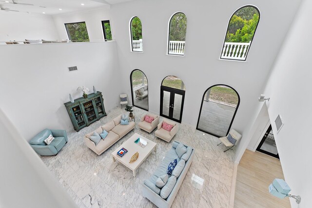 living room featuring french doors, a high ceiling, and light wood-type flooring