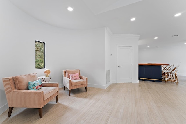 sitting room featuring light hardwood / wood-style flooring and crown molding