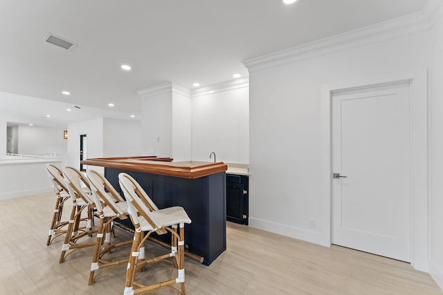 bar with indoor wet bar, recessed lighting, visible vents, ornamental molding, and baseboards