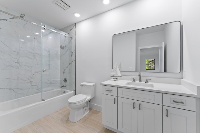 full bathroom with baseboards, visible vents, toilet, shower / bath combination with glass door, and vanity