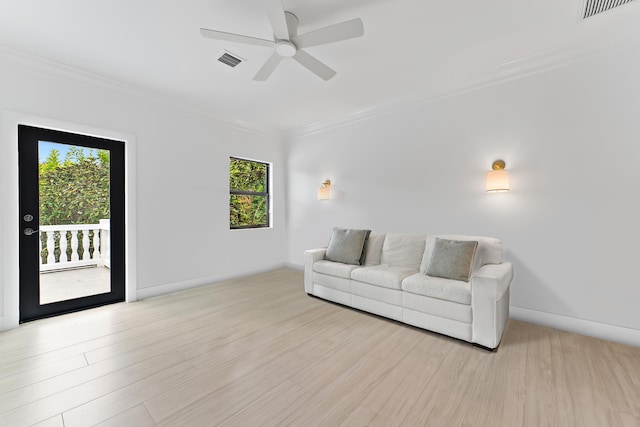 living room featuring ceiling fan, light wood-type flooring, and ornamental molding