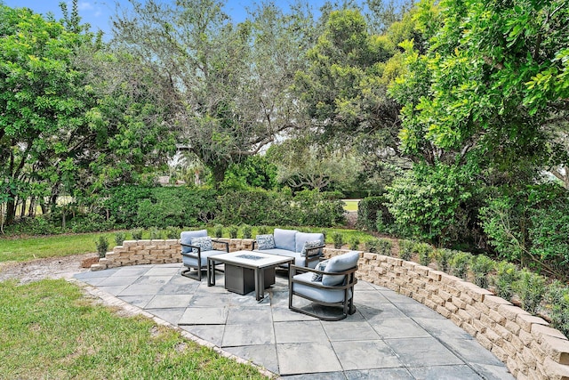 view of patio with an outdoor living space with a fire pit