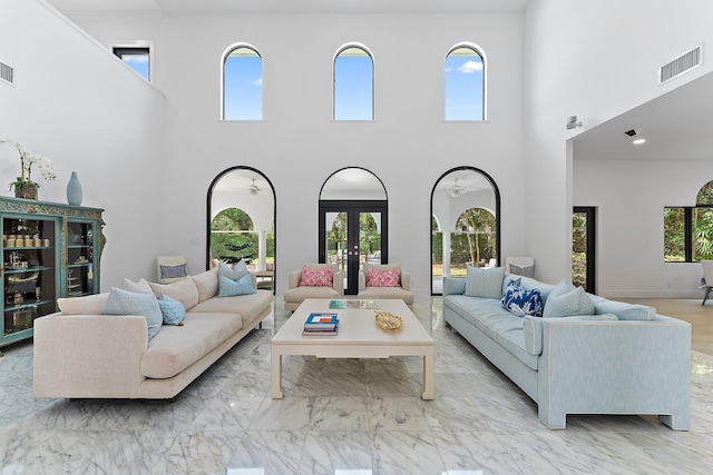 living room with french doors and a towering ceiling