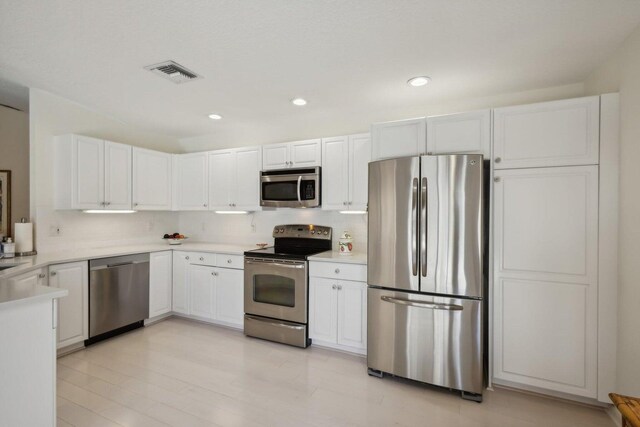 kitchen featuring light hardwood / wood-style flooring, stainless steel appliances, and white cabinets