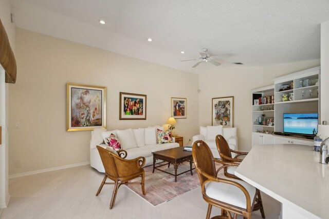 interior space featuring lofted ceiling, ceiling fan, and a textured ceiling