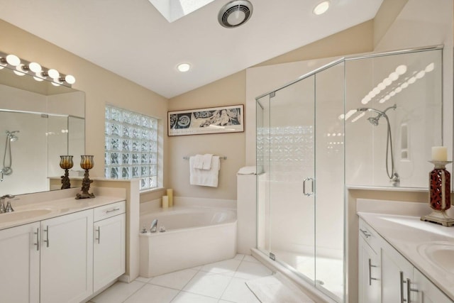 bathroom with tile patterned flooring, vaulted ceiling with skylight, independent shower and bath, and vanity