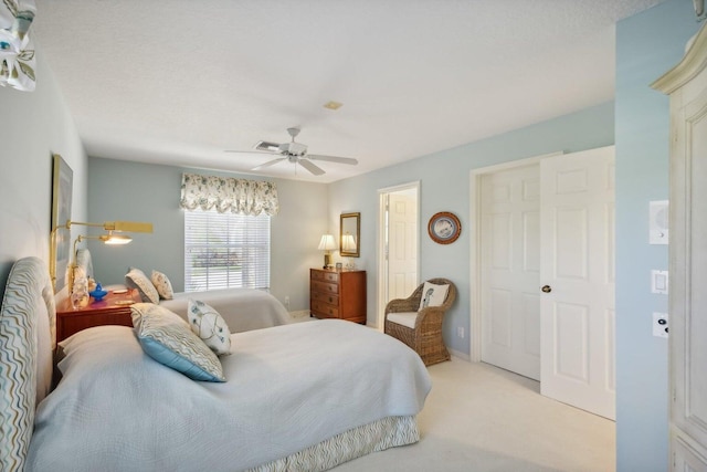 bedroom with a textured ceiling, light colored carpet, and ceiling fan