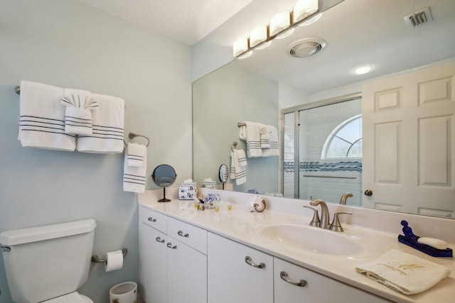 bathroom featuring vanity, toilet, and walk in shower