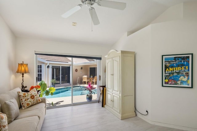 living room featuring lofted ceiling, ceiling fan, and light wood-type flooring