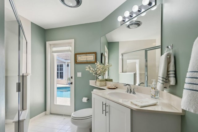 bathroom featuring tile patterned flooring, vanity, toilet, and walk in shower