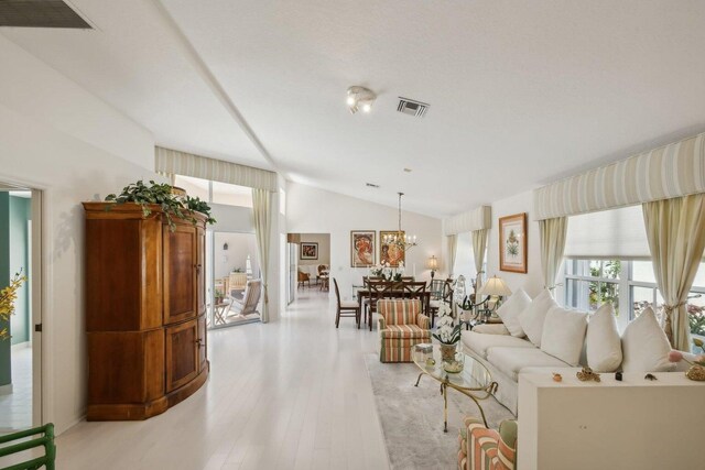 living room with vaulted ceiling and light hardwood / wood-style floors