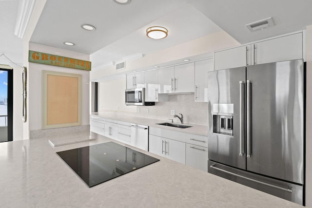 kitchen featuring visible vents, a sink, stainless steel appliances, light countertops, and white cabinetry