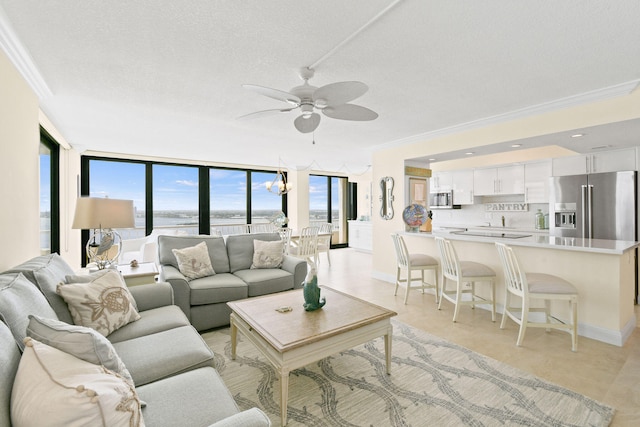 living area with expansive windows, a textured ceiling, ceiling fan, and crown molding