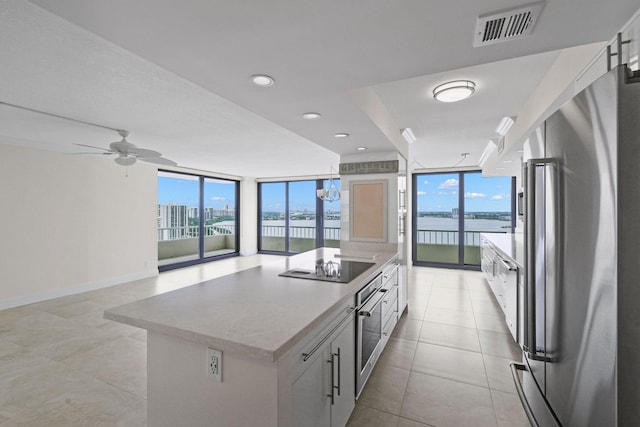 kitchen with floor to ceiling windows, white cabinetry, a healthy amount of sunlight, and appliances with stainless steel finishes