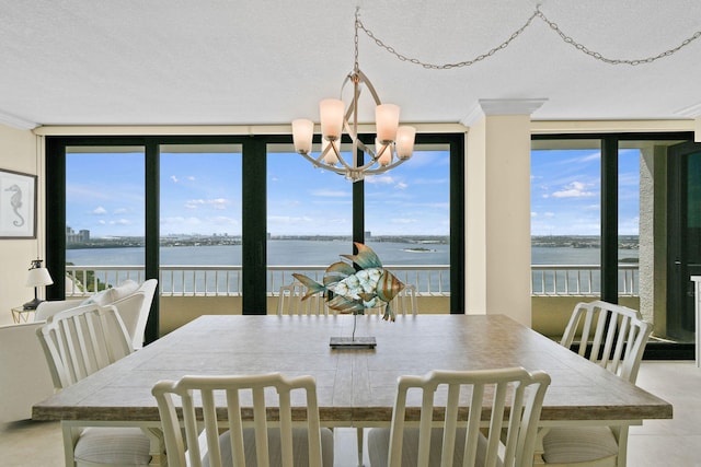 dining space with an inviting chandelier and a water view