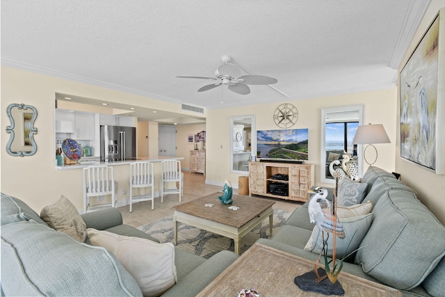 living area with visible vents, a textured ceiling, crown molding, and ceiling fan