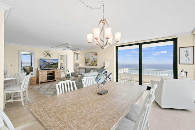 dining space with a fireplace, ceiling fan with notable chandelier, and ornamental molding