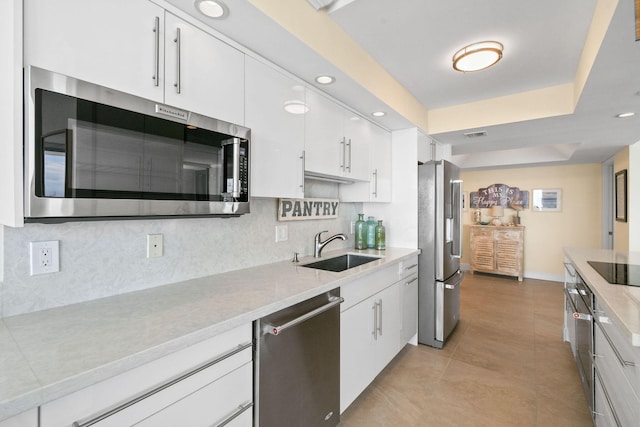 kitchen featuring white cabinetry, sink, stainless steel appliances, decorative backsplash, and light tile patterned floors