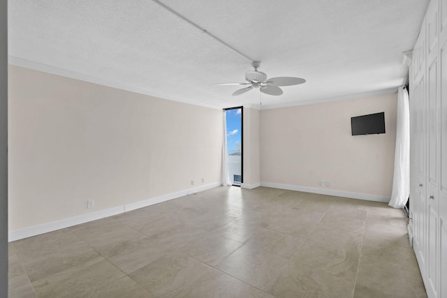 empty room featuring baseboards, a textured ceiling, ceiling fan, and crown molding